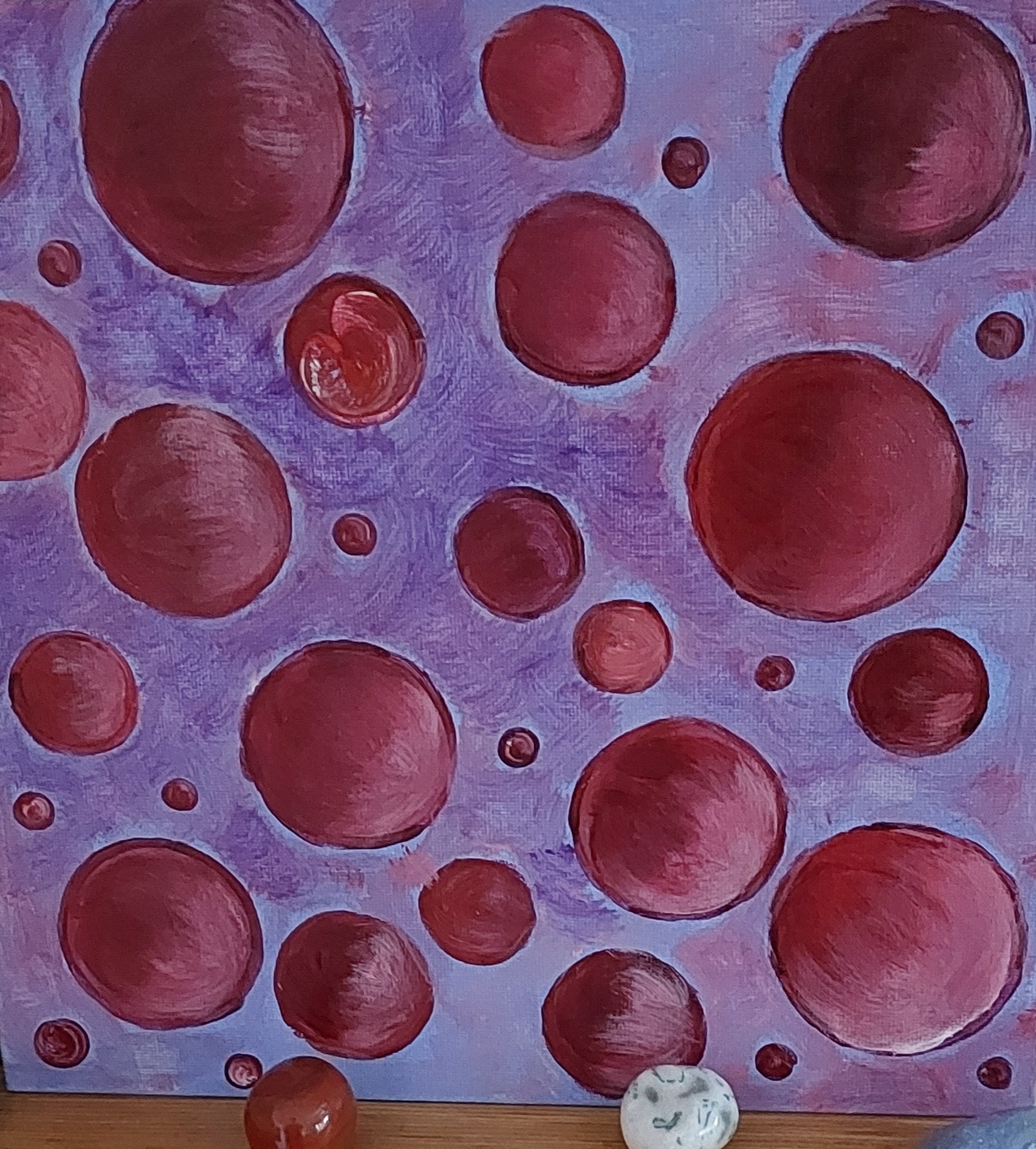 Bild mit roten Kreisen verschiedener Größe auf lilafarbendem Hintergrund