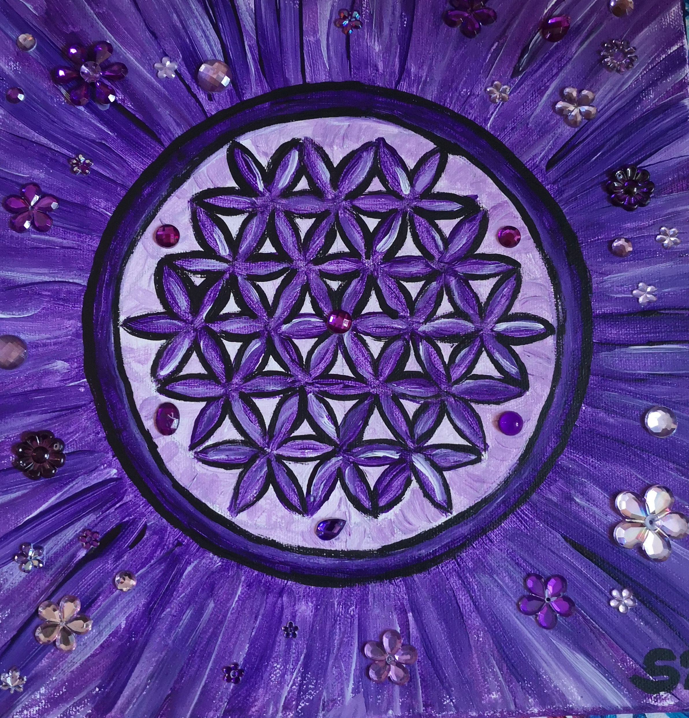 Bild eines Muters aus Blüten in einem Kreis mit Steinchen und Blumen aus Glas